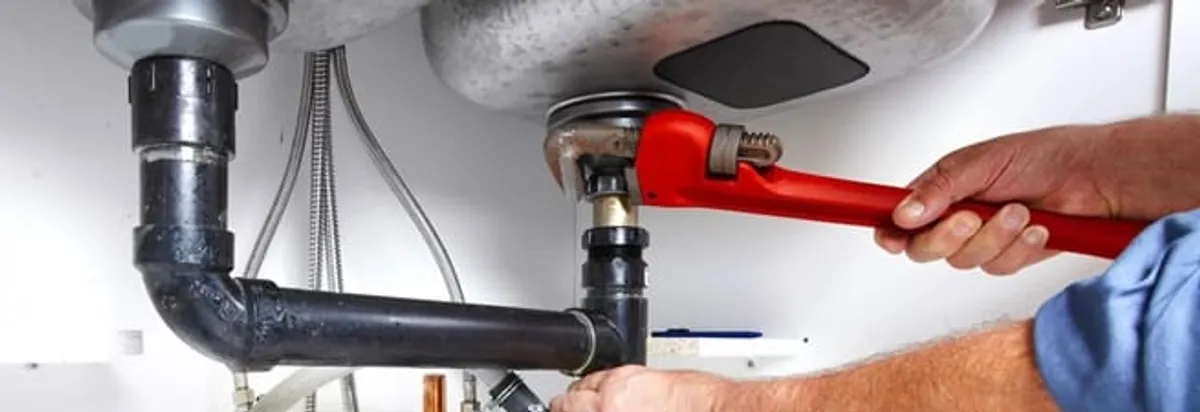 Garbage disposal repair technician tightening the sink drain and disposal connection in South Bend, IN